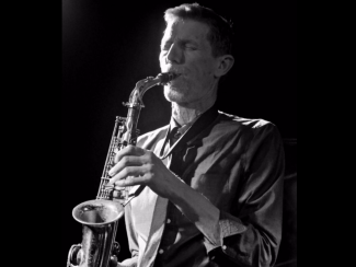 Black and white photo of Steve Buckley playing a saxophone